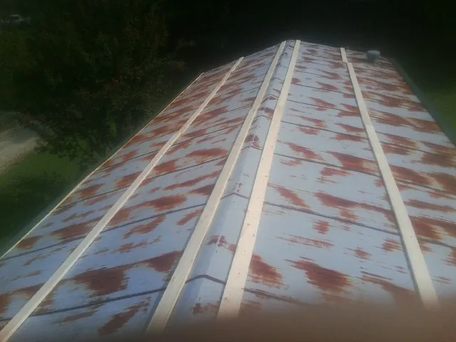 Rusted metal roof panels with new wood purlins before replacement — Storm Damage Roof Repair in Valley Stream by Roofing Brothers