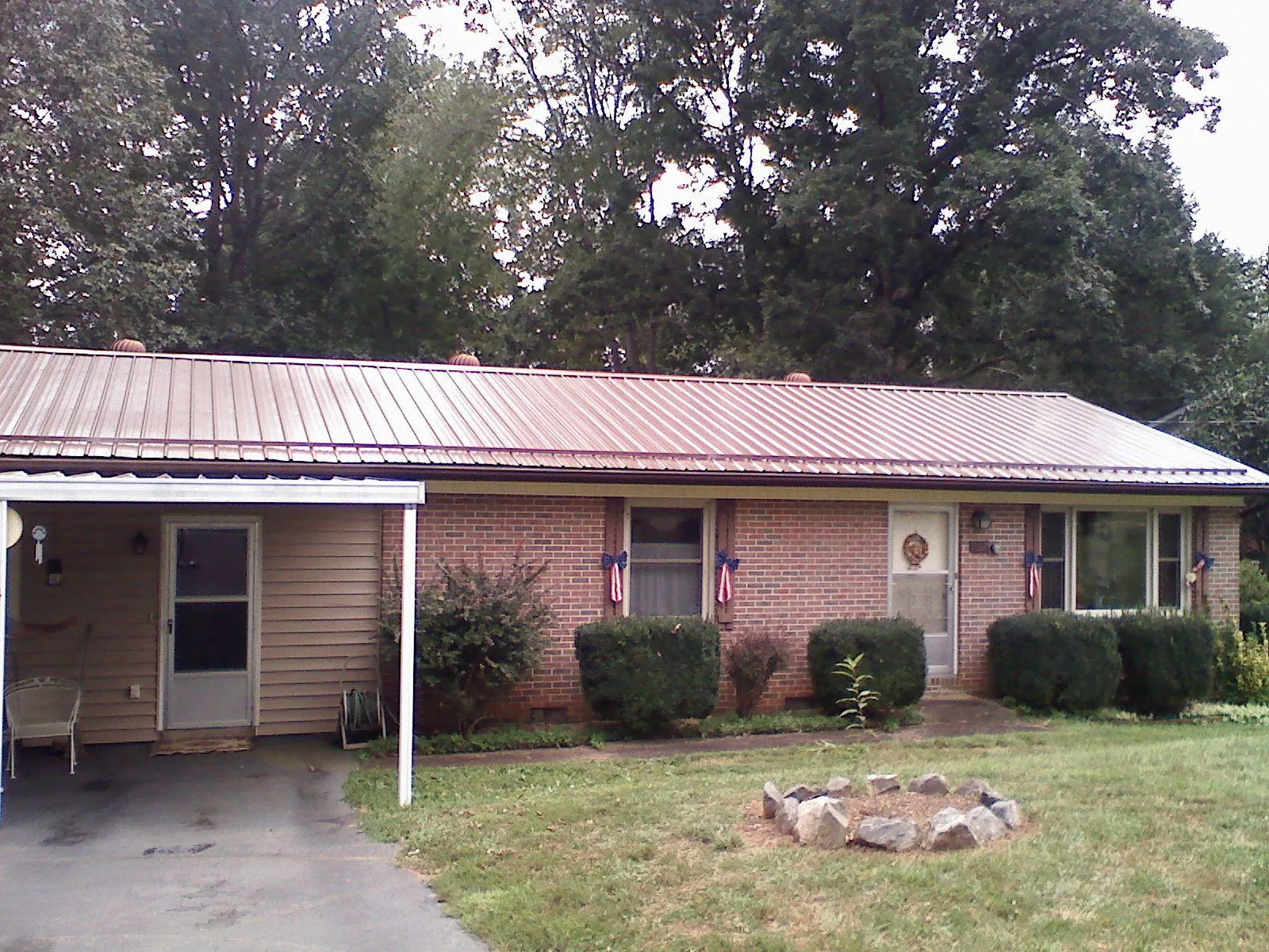 Bronze metal roof and carport on a brick ranch home — Roof Repair work by our crew in Valley Stream